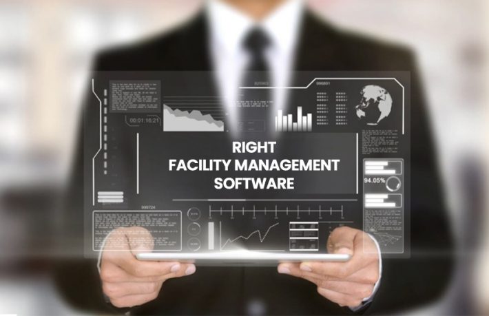 Business professional holding a digital interface with graphs and charts representing facility management software