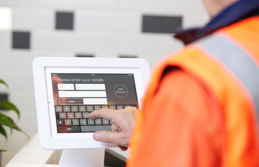 Person using a digital visitor management system at a facility entrance